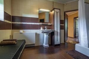 toilet and detail of a corner shower cabin with wall mount shower attachment photo