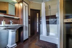 toilet and detail of a corner shower cabin with wall mount shower attachment photo