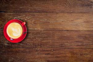 rojo café taza en antiguo madera antecedentes con espacio. foto