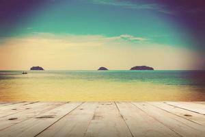 Wood table and Blue sea in summer beach for background with vintage tone. photo