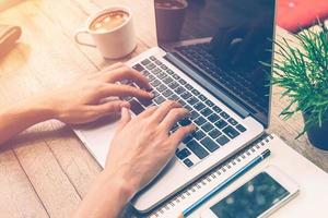 Young business man using laptop working in coffee shop with vintage filter. photo