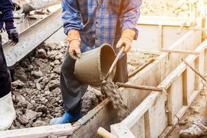 worker mixing cement mortar plaster for construction with vintage tone. photo