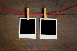 two blank photo frame hanging on wood background with space