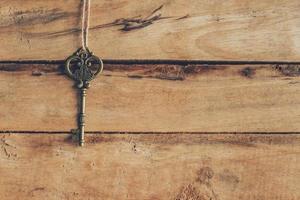 old key hanging on wood background texture with copy space photo