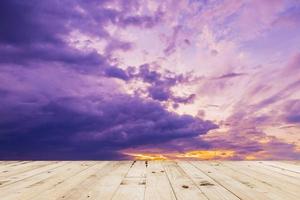 wood table and dramatic clouds sunset in thailand. photo