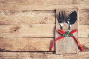 christmas table place setting and silverware on wood with space. photo