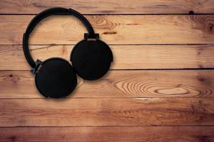 Headphone on wood background and texture with space photo