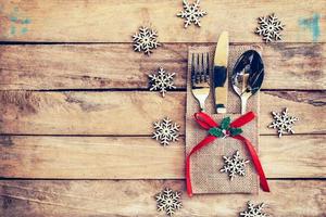 christmas table place setting and silverware, snowflakes on table wooden background with space for christmas. photo