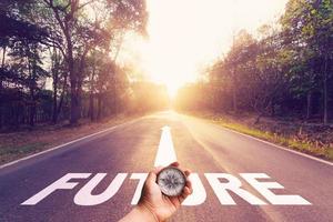 Hand holding compass on Empty asphalt road and Future concept. photo