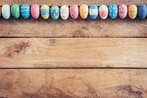 Colorful pastel easter eggs on wooden background with space. Vintage toned. photo