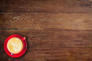 red coffee cup on old wood background with space. photo