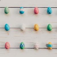 Easter eggs on wooden background. Pastel colorful easter eggs and hand paint on wooden background. photo