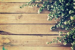 Flowers on wood texture background with copyspace. Vintage style. photo