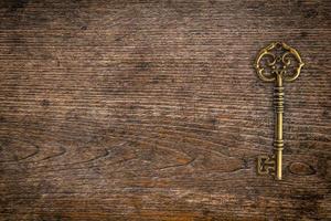 Vintage key on wood texture and background with space. photo