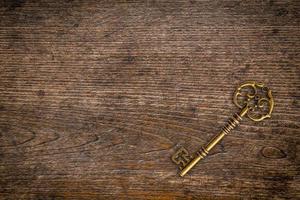 Vintage key on wood texture and background with space. photo