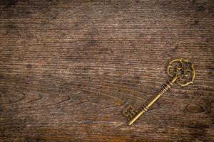 Vintage key on wood texture and background with space. photo