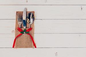 Christmas table place setting and silverware on wood with space and Table setting on wood background vintage. photo