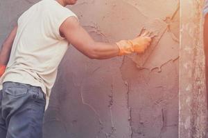 hombre yesero maestra hormigón en cemento para pared en edificio construcción con Clásico tonificado foto