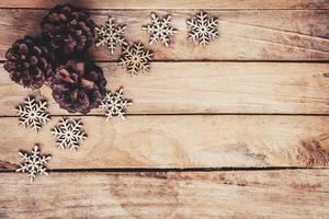 pino conos y copos de nieve en madera para Navidad antecedentes con espacio. foto