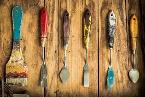 old paintbrush and trowel for color on wooden photo