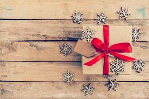 Brown gift box and snowflakes on wood for christmas, new year background. photo