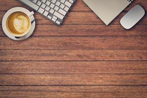 Office table with notepad, computer and coffee cup and computer mouse. View from above with copy space photo