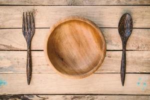 wooden bowls and spoon with fork on wood background photo