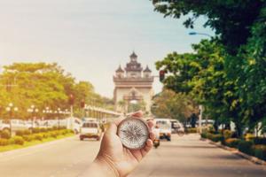 Hand man holding compass on road Victory Gate Patuxai, Vientiane, Laos, Southeast Asia photo