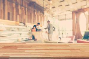 vacío madera mesa y borroso antecedentes monitor a café tienda con espacio para producto. foto