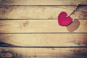 Two red and brown heart on wooden background with vintage style. photo