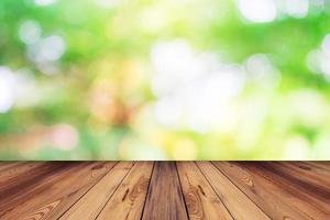 Green bokeh blur background and wood table in garden photo