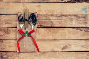 Christmas table place setting and silverware on wood with space and Table setting on wood background vintage. photo