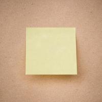 yellow sticky note on brown paper texture close up photo