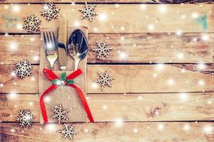 christmas table place setting and silverware, snowflakes with snow winter on table wooden background photo