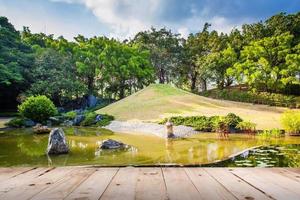 madera piso en estanque y agua paisaje en japonés jardín foto