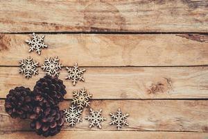 pino conos y copos de nieve en madera para Navidad antecedentes con espacio. foto