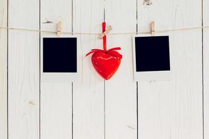 dos foto marco blanco y rojo corazón colgando en blanco madera con espacio. enamorado antecedentes.