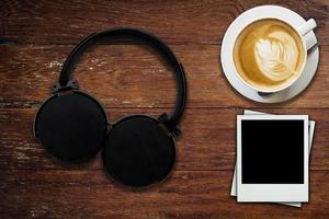 Headphone coffee and photo frame on wood background and texture
