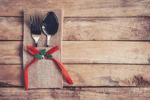 christmas table place setting and silverware on wood with space. photo