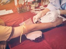 close up hand man and nurse taking a blood sample with vintage filter. photo