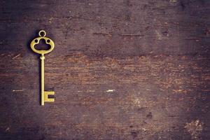 old key on wood background with space photo