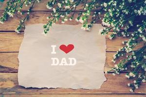 yo amor papá y contento padres día en marrón papel con blanco flor en de madera tablero