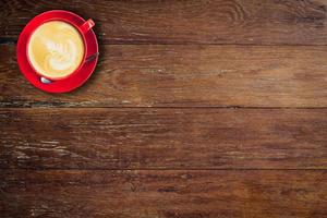 rojo café taza en antiguo madera antecedentes con espacio. foto