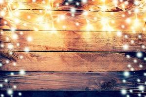 christmas light and snow on wooden background with space photo