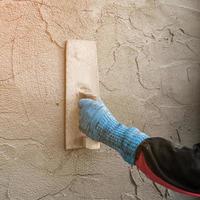 plasterer concrete worker at wall of house construction photo