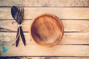 wooden bowls and spoon with fork on wood background photo