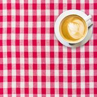 cappuccino coffee on white and red checkered background close up photo