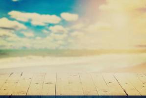 empty wood table on blurred sand beach with vintage effect. photo