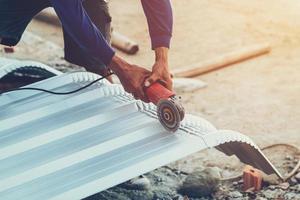 close up hand man use steel cutting to roof metal photo