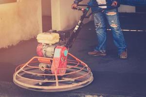 Plasterer working using scrubber machine for cement floor with vintage toned photo